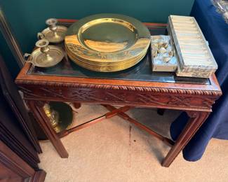 Brass charger plates and carved glass top side table