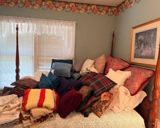 Mahogany four poster bed with throw pillows and linens