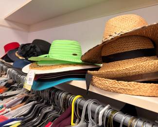 Straw sun hats and hangers of clothing