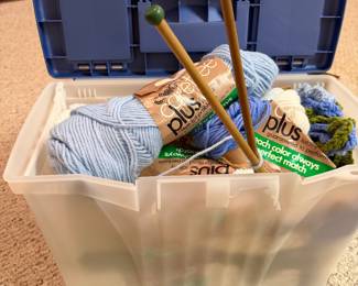 Box full of yarn and knitting needles