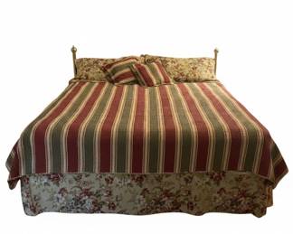 Brass Bed Frame with Floral Bedding and Striped Comforter