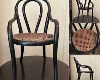 A miniature Bentwood chair with dark ebonized finish and a woven cane seat