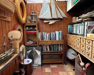 A view of some of nautical items including wooden model boats and ships, vintage life preservers, ship hull models, antique/vintage ship's lanterns; an antique barrister oak bookcase; vintage lobster trap buoys