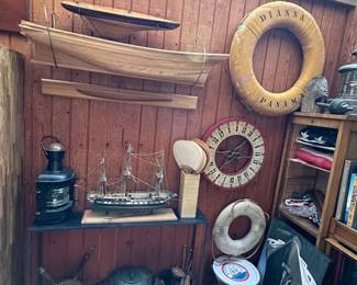 Half hull boat models, a vintage Schillbach Stettin ship's lantern, a large vintage ship's lantern marine light, with galvanized steel body and a clear, ribbed Fresnel glass lens; vintage ship's life rings/life preservers, a vintage gaming / carnival / gambling game spinning wheel, nautical and American flags, an Art Deco-style print of the ocean liner Normandie