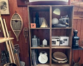Vintage Native American snowshoes, a decorative model of a lifeboat, a nautical-style carved and painted wooden sign reading "Aura Lee," a pair of wooden book cases, a vintage duck decoy, a vintage Schillbach Stettin ship's lantern, vintage woven baskets, a large white alarm clock with double bells, a vintage metal ship's wheel