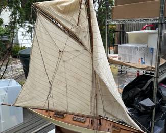 A large wooden ship model of a sailing yacht, with linen sails
