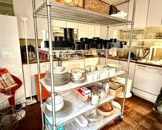 Sets of Mikasa Black Plus dishware, set of Franciscan Masterpiece China, nested mixing bowls, coffee grinder, Braun stick blender in original box, woven picnic baskets, miscellaneous kitchen gadgets, and a commercial-grade steel wire shelving unit with caster wheels