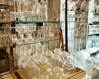 Glassware including lidded storage jars, balloon wine glasses, champagne coupes, brandy snifters, mugs, vases, and beakers