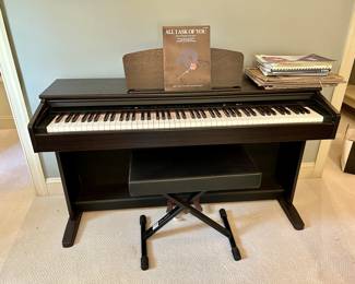 Yamaha digital piano with bench and sheet music
