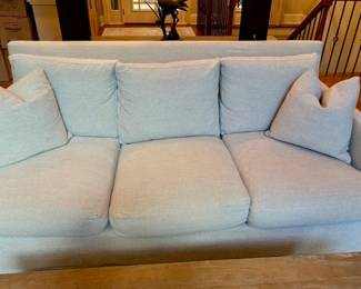 Light blue upholstered sofa with accent pillows