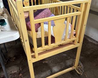 Antique crib on metal wheels