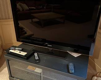 Black flat screen TV sitting on a grey media console