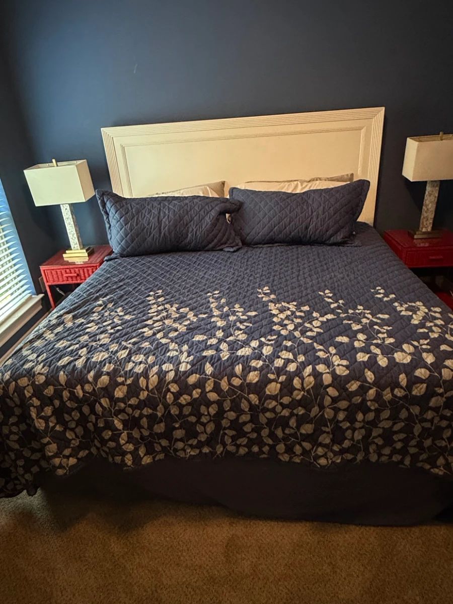 Navy Blue Botanical Leaf Pattern Quilt Set with White Panel Headboard, Red Wicker Nightstands, and Table Lamps