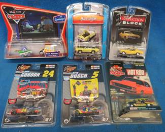 Lot 72. NIP collectible cars: Two 1:64 Green Light. Kyle Busch 1:64 Winner's Circle. Jeff Gordon 1:64 Winner's Circle. One Racing Champions. One Disney