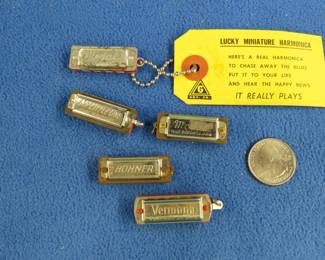 Lot 165. Five novelty miniature harmonicas: Hohner Little Lady 1 3/8" 4-hole diatonic. Sounds great. F.A. Rauner My Little One 1 3/8" 5-hole diatonic. Sounds great. Medao made in Japan 1 3/8" diatonic. Sounds great. Lucky Miniature Medal 4-hole blow only. Verona 5-hole diastonic harmonica. Sounds great.