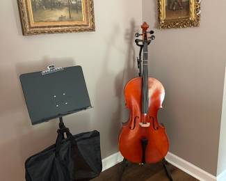Student cello with carrying case (not pictured) and music stand; oil paintings