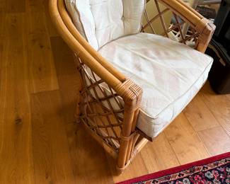 tage 1970s corbeille-style armchair features a rounded backrest, woven lattice framework, and bent rattan construction. It is a quintessential piece of mid-century tropical and boho-chic design, often referred to as a coastal or Palm Beach Regency accent chair.