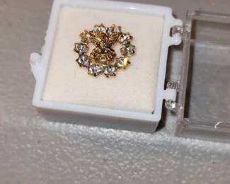 Gold Tone eagle lapel pin surrounded by a ring of rhinestones