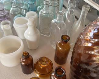 A VERY small sampling of antique and vintage glass bottles, amber medicine bottles, milk glass and small vases.
