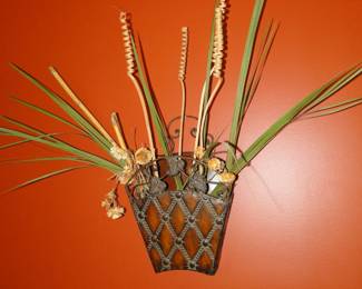 Palm fronds, in metal basket, mounted on the wall