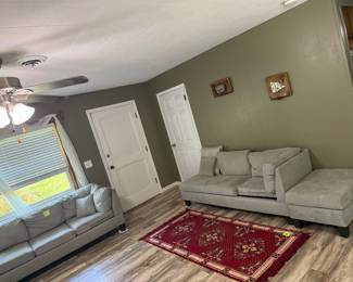 Sectional couch, vintage rug, cute vintage sea art on walls