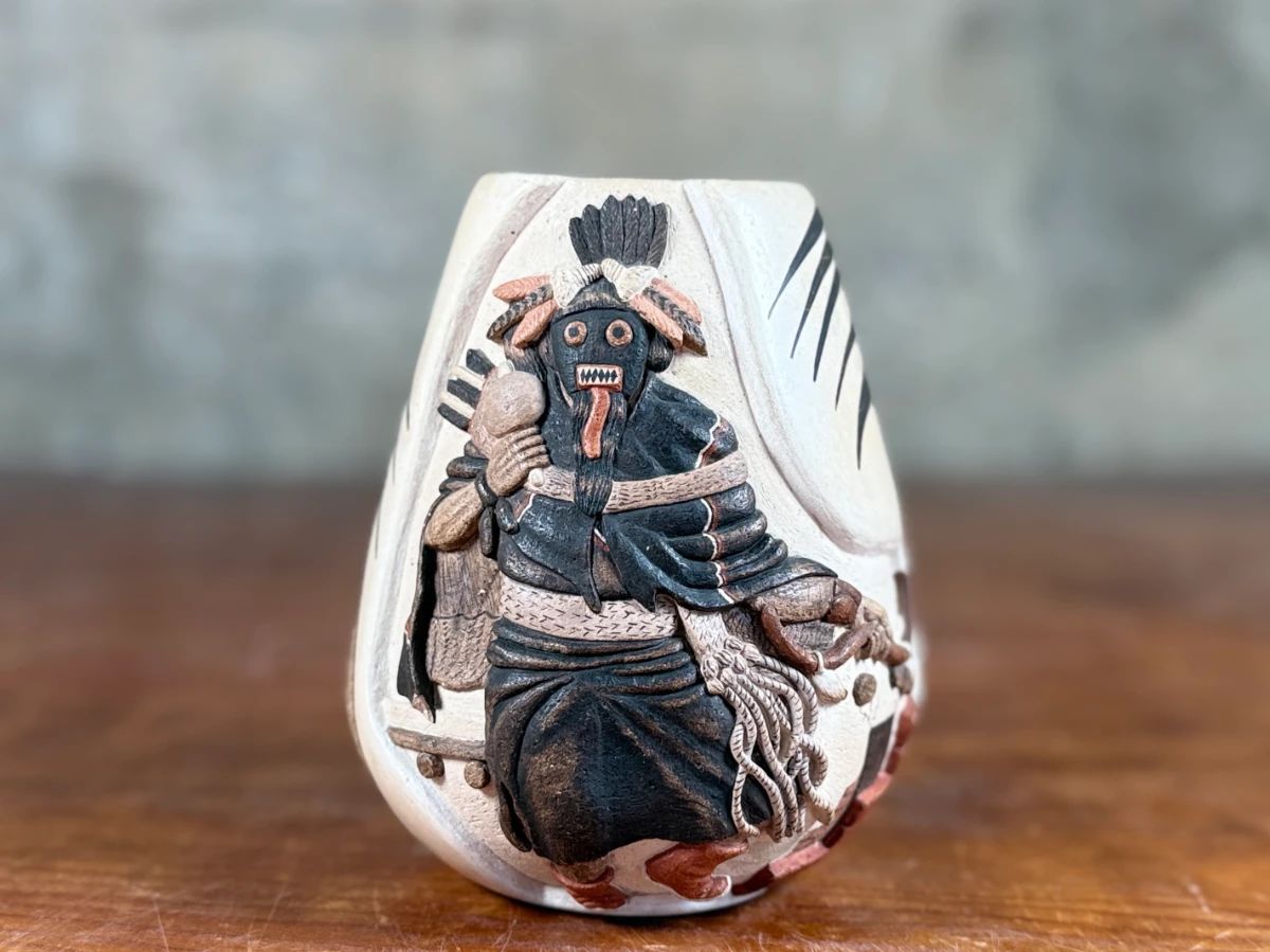 This lot features an authentic Hopi vase by listed artists, Harrison Jim Senior & Marianne Navasie. Signed underneath as shown in photos, tiny chip(s) shown and measures, 5.5” H x 4.5” W.