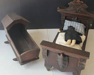 Lot 83: Antique carved wooden doll bed with doll and cradle piece