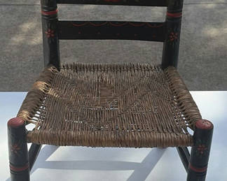 Lot 27: Small black-painted wooden chair with woven seat and floral decoration