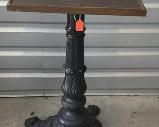 Lot 35: Ornate cast-iron pedestal table with wooden top