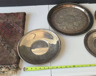 Lot 79: Assorted silver plate serving trays and bowls with a patterned woven rug
