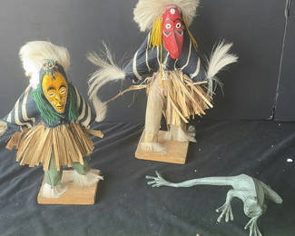 Lot 56: Two straw-skirted masked figures with a green frog sculpture