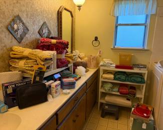 Looking into the hall bathroom, lots of towels, mid-century art, bathroom weighing scales, etc.