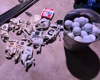 Lots of golf gloves & bucket of golf balls