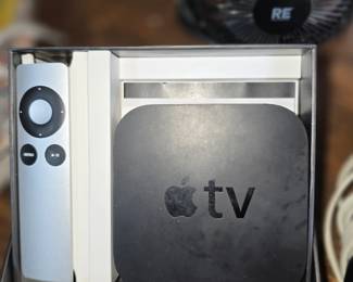  This is an Apple TV streaming device, likely a 3rd Generation model based on the silver remote.