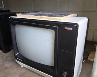 vintage television appears to be a 1980s portable CRT model with a white chassis and black screen bezel.