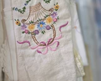 hand-embroidered linen dresser scarf features a prominent basket design adorned with colorful floral embroidery.