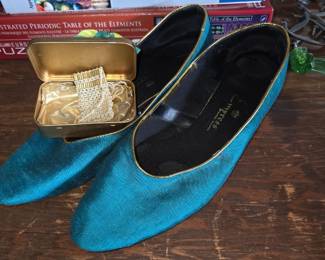 teal satin heels are likely from the brand Impress and feature a gold-colored trim along the top edge.