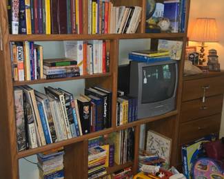 Large vintage wall unit full of books and vintage TV with VCR
