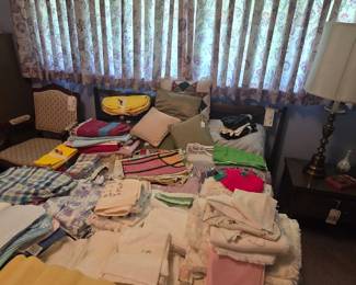 Bed is loaded with vintage linens. Top left, PETER MAX TEA TOWEL!! WHAT?!?!?!
