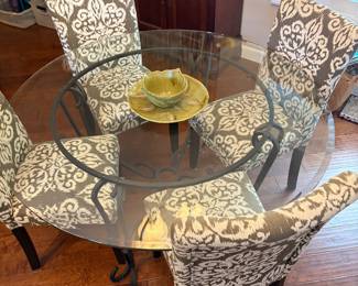 Glass dining room table with four upholstered chairs