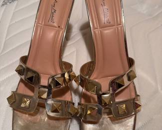 Gold, studded slip-on sandals with a square toe and block heel.