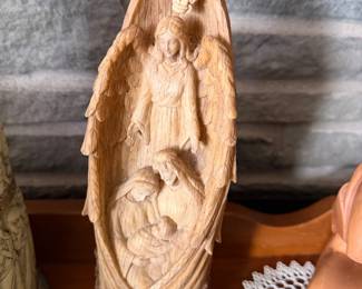 11-inch tabletop statue features a wood-like carved design depicting the Holy Family enclosed by an angel's wings