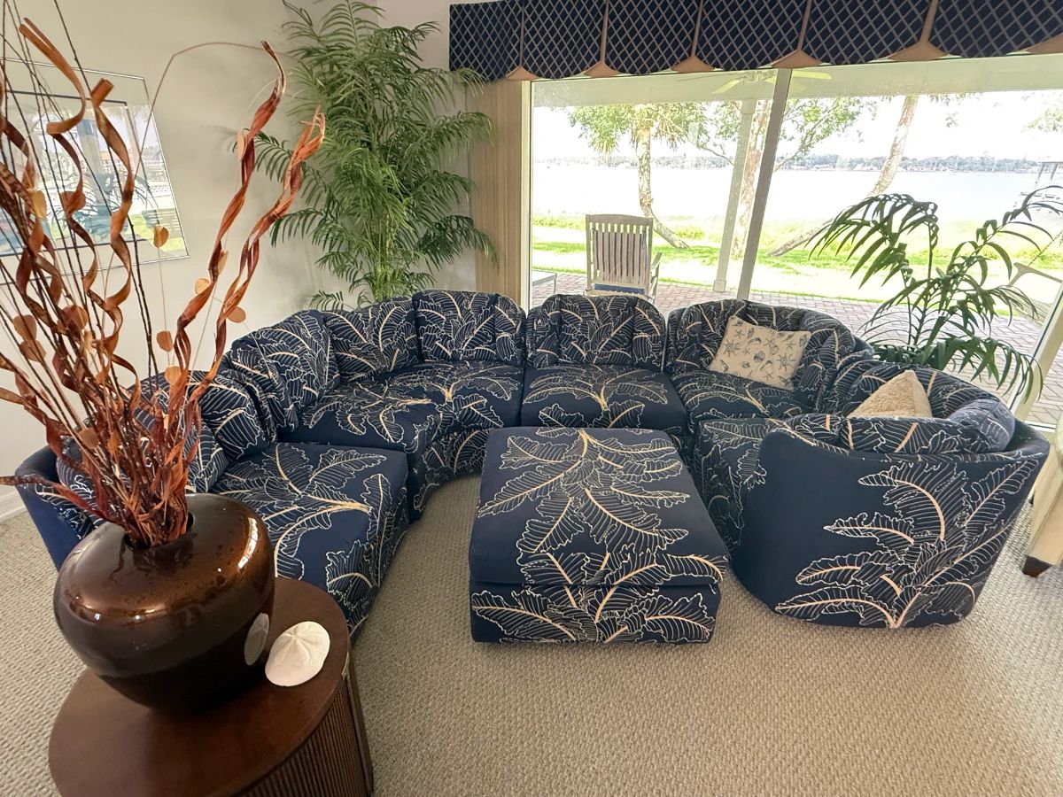 6 piece Coastal/Palm Beach Regency design modular sectional sofa with ottoman features vibrant navy blue fabric with a tropical leaf pattern