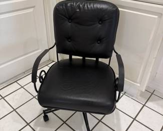 Black swivel chair with tufted upholstery and wheel base