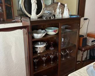 Display Cabinet with serving pieces and religious sculptures
