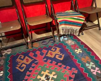 Norcar Industrial metal folding chairs with tilt backs, African rug, Native American hand made rug on chair