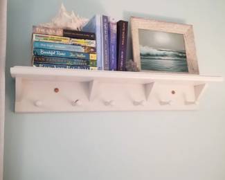 Wall shelf with clothing pegs