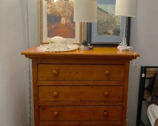 Another couple of framed art can be seen resting on the top of the five-drawer dresser in this photo.  Don't forget the lamps.