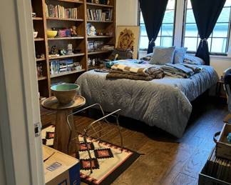 There are books to look through on those shelves, plus the lion artwork, area rug, small round table and bowl, and the bed, of course.