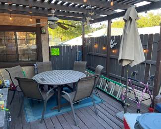 Outside again, there is another table and chair set, an extendable straight ladder, a string of area lights, a stand umbrella, and lots more.